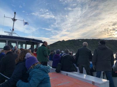 Group of people on a boat looking at the cliffs. 