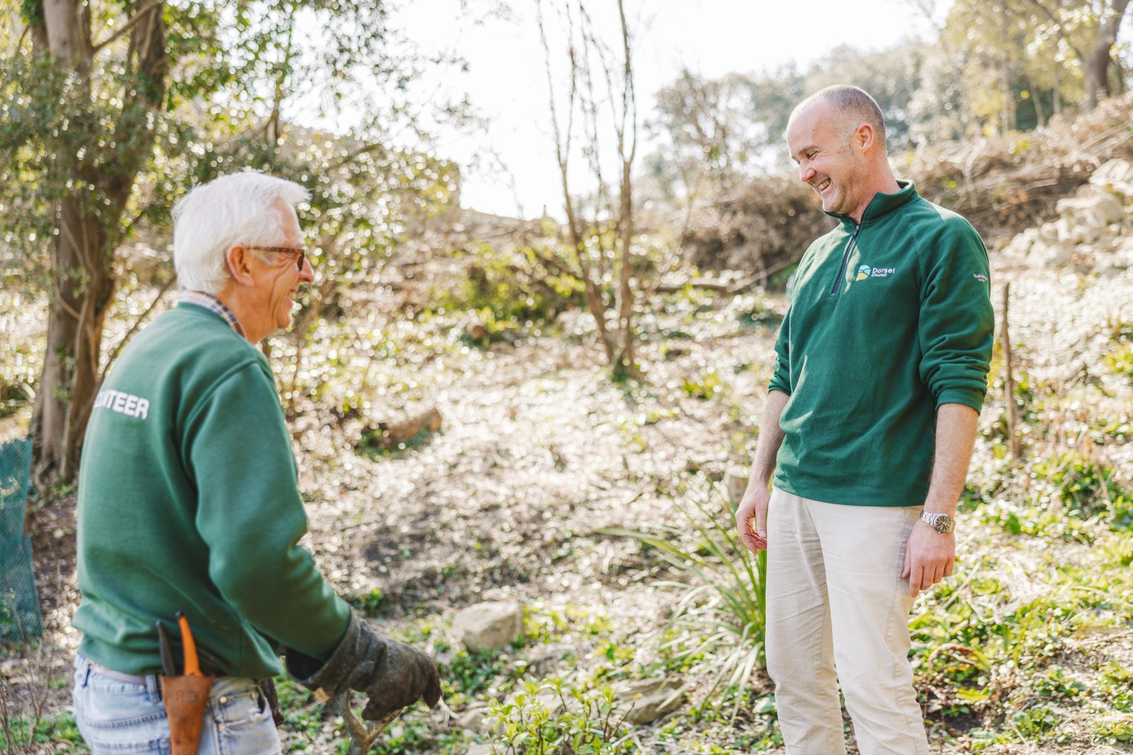 Volunteer and ranger laughing while planting trees